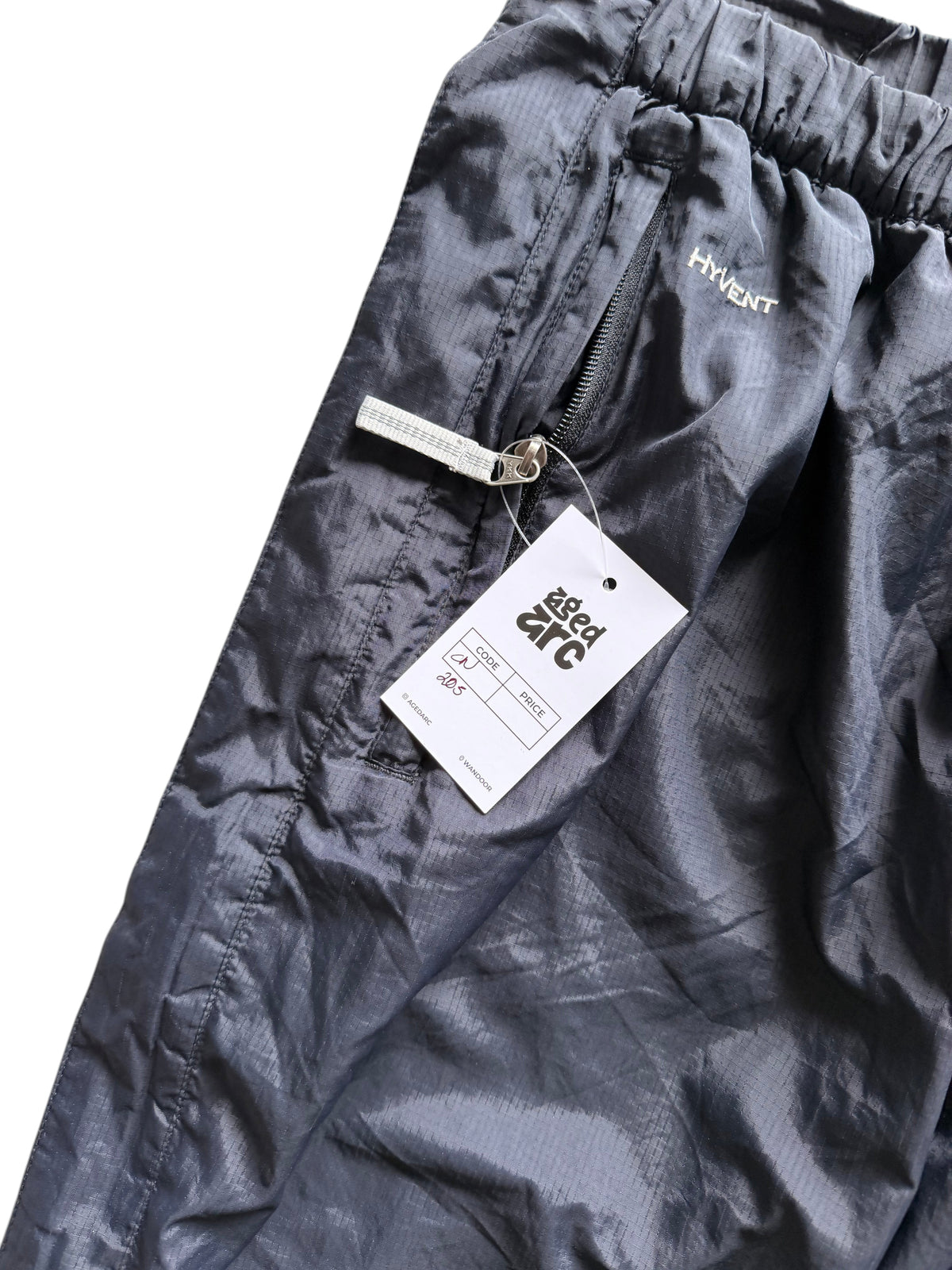 Aged Arc black nylon track pants featuring a zippered pocket and Hyvent branding detail.